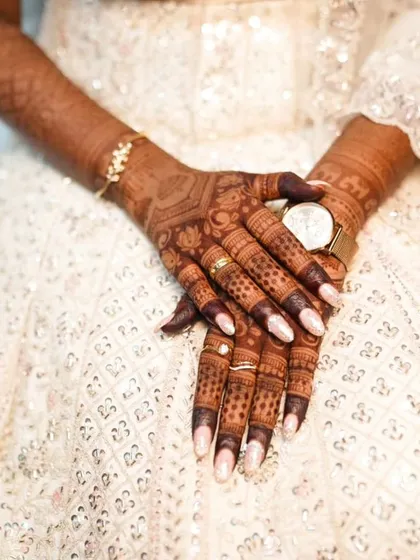 A close-up of the fingers, showing the dark, even stain and how it complements the bride's manicure.