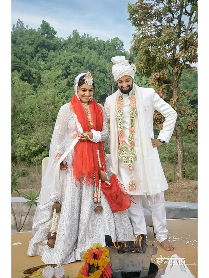 A posed shot of the couple after their pheras, standing by the sacred fire, officially husband and wife.