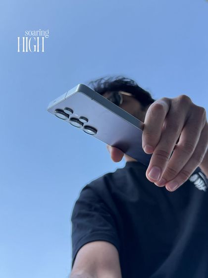A dynamic, low-angle shot of me holding the new Samsung phone. This type of image is perfect for tech brands, conveying a sense of power and being ahead of the curve.