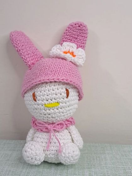 This bunny is wearing a pink hoodie with a flower on it, inspired by the character My Melody.