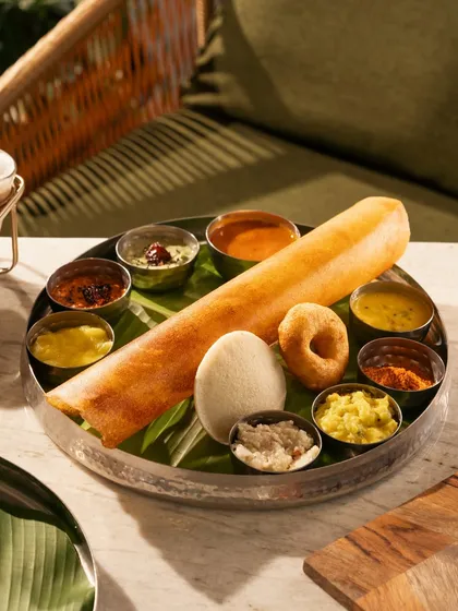 A complete South Indian breakfast platter with dosa, idli, vada, and various chutneys. This is a feast for the eyes.