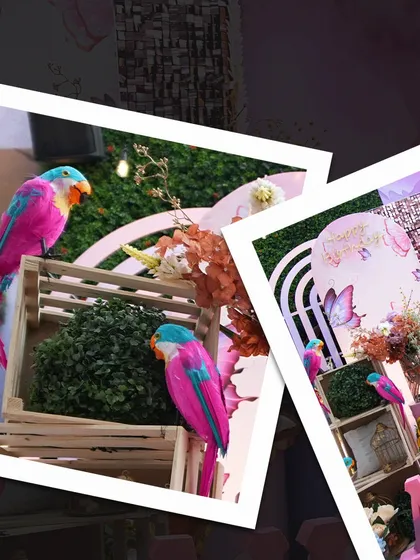 A closer look at the details from Aurica's butterfly-themed party. We used colorful parrot figures and wooden crates with greenery to add texture and depth to the main decor setup.