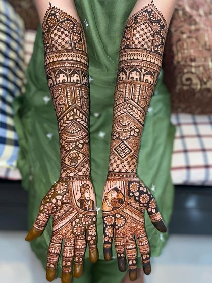 A clear, full view of the intricate portrait mehandi, showing how all the elements from the palms to the elbows come together in a cohesive design.
