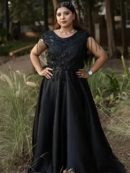 This black off-shoulder gown with fringe sleeve details is perfect for a cocktail party. It’s a modern and stylish option available for rent.