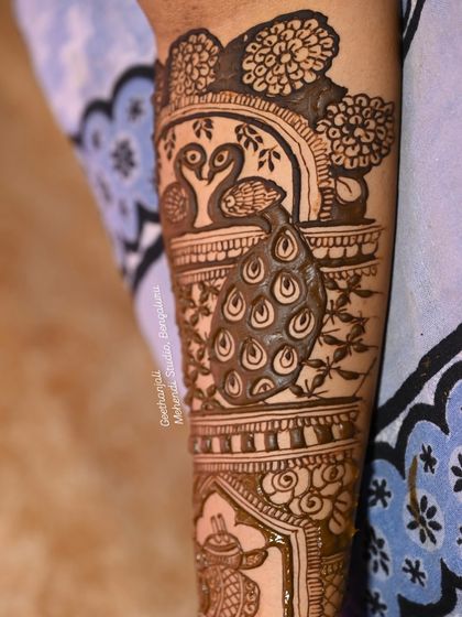 A close-up of the peacock motif on the arm, with beautiful shading and detail.