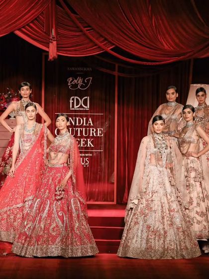 The grand finale of a show at India Couture Week. This wide shot captures the entire collection on the runway, showcasing the designer's vision.