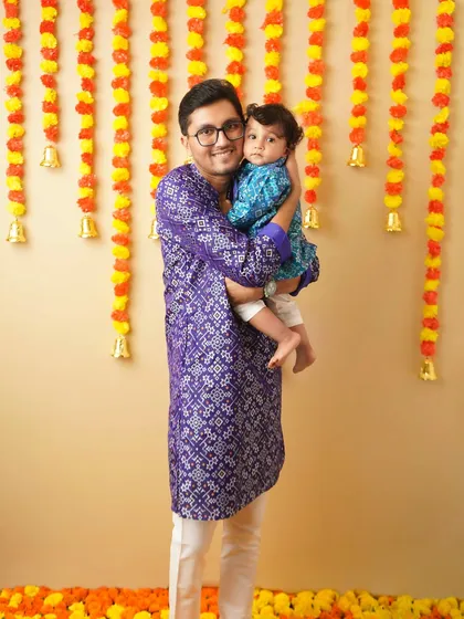 A father and son, dressed in matching traditional kurtas, share a sweet moment during their festive photoshoot. These are the memories that define family traditions.