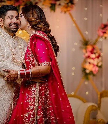 A happy kiss on the cheek. This candid shot perfectly captures the joy and love of the wedding celebration.