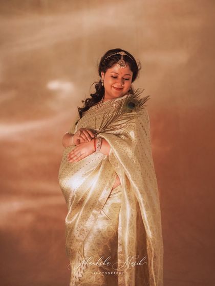 A beautiful experiment with golden light, this portrait in a shimmering saree has a warm, dreamlike quality. The peacock feather adds a touch of divine symbolism.