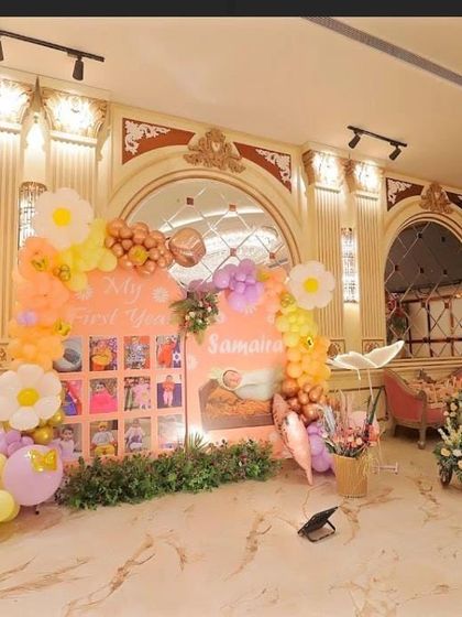 A "My First Year" photo board, beautifully integrated into the party's flower and butterfly theme.