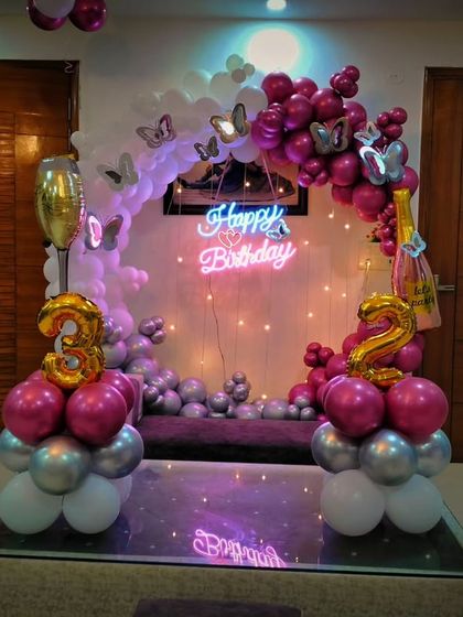 A full view of the 32nd birthday setup, showing the beautiful balloon arrangement with a neon sign, number balloons, and a champagne bottle balloon, creating a complete and festive look.