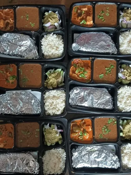 A catering order featuring Dal Makhni and Kadai Paneer thalis. I ensure every plate has a good portion of all items, including salad.