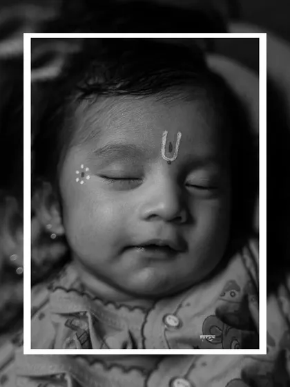 Sometimes, the most powerful portraits are the most peaceful. This is a close-up black and white shot of baby Krishiv, sleeping soundly. I focus on capturing these serene details, from the calm expression to the traditional tilak, creating a timeless memory of your baby's earliest days.