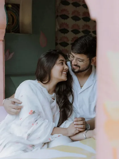 A lovely, natural portrait of the couple sharing a happy, relaxed moment together in a colorful and cozy cafe setting.