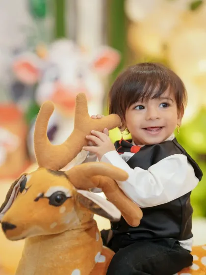 The birthday boy enjoying a ride on a toy deer. Capturing these moments of play and imagination is a key part of my event photography service.