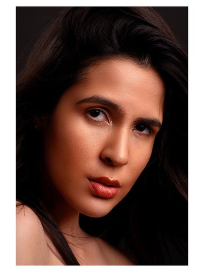 A close-up beauty shot with a focus on the model's direct gaze. The simple composition and clean lighting make this a powerful and engaging portrait.