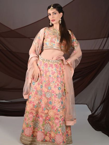 A full-length portrait of the peach floral lehenga, showing its elegant A-line silhouette. It’s a versatile piece for both bridal and non-bridal shoots.