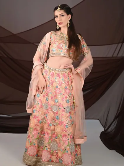 The model strikes a pose in the full peach floral lehenga, showcasing its beauty and elegance. This is a must-rent for your next event.