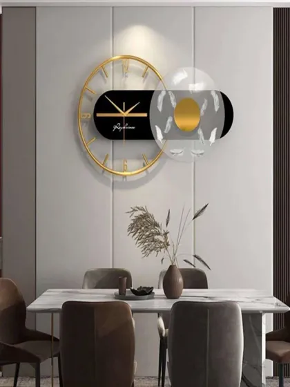 This imported wall clock showcases a horizontal design with a transparent, feather-detailed element. The mix of black, gold, and clear acrylic creates a light, airy, and thoroughly modern piece of wall decor.