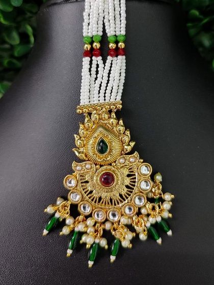 A beautiful beaded maang tikka with a traditional gold-finish pendant.