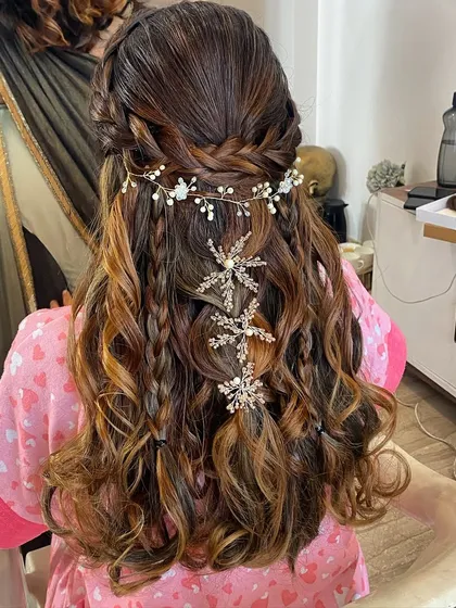 Hair stories. A romantic half-up style with braids and curls, decorated with a delicate hair vine.