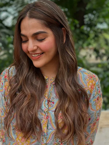 Getting her holiday-ready with a rich blend of copper and caramel highlights. This warm, wavy style is perfect for a festive getaway.