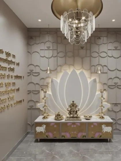 We created a unique focal point in this pooja space with a large, backlit lotus flower design. The Gayatri Mantra is engraved in elegant gold lettering on the wall, complemented by a modern chandelier and a custom cabinet with a subtle floral print.