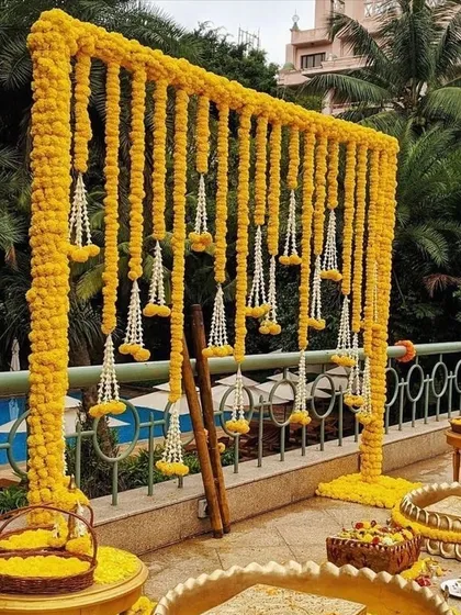 This unique photo booth for a Haldi ceremony is made entirely of fresh marigold strings, creating a stunning wall of flowers. It's a simple but incredibly effective backdrop for beautiful pictures.