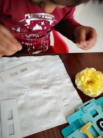 A child preparing a slide with a flower petal for his paper microscope. This hands-on science is both fun and educational.