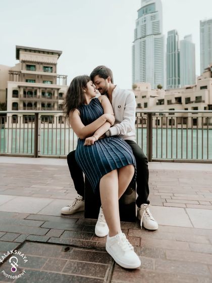 An intimate and romantic embrace on a walkway in Dubai, with the city's modern architecture providing a stunning backdrop.