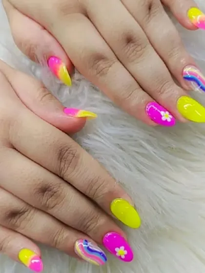 A vibrant and playful neon set, featuring bright yellow and pink nails with rainbow swirls and daisy art.