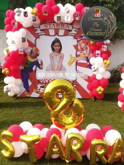 Here is the carnival backdrop complete with large gold foil letters spelling the birthday girl's name, "STARRA", and the number '8'. This creates a perfect spot for cake cutting and birthday photos.