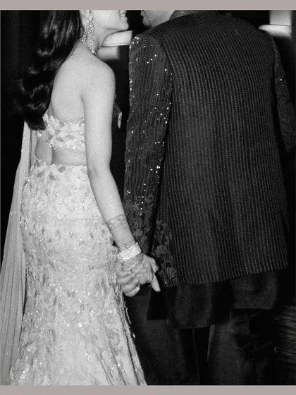 A close-up, black and white shot of the couple holding hands as they walk, a simple gesture full of meaning.