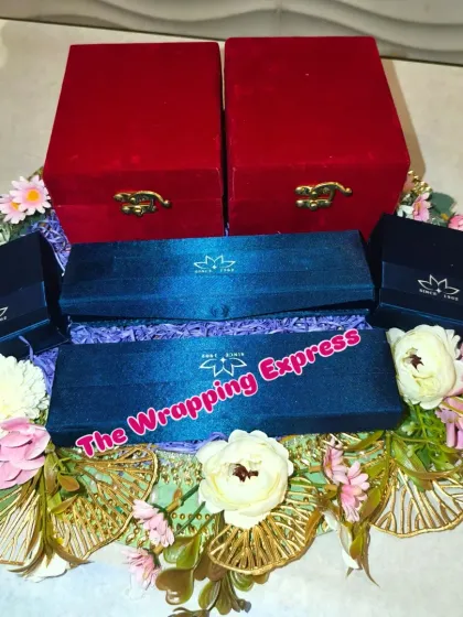 The finished jewellery platter for the Kua Poojan, with red and blue boxes beautifully arranged with artificial flowers.