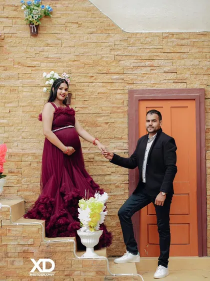 A romantic pose on a rustic staircase, with the partner gently holding the mother-to-be's hand.