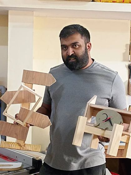 Nithant with the two very different projects he built. One is a directional signpost, and the other is a clock holder, showing the range of possibilities.
