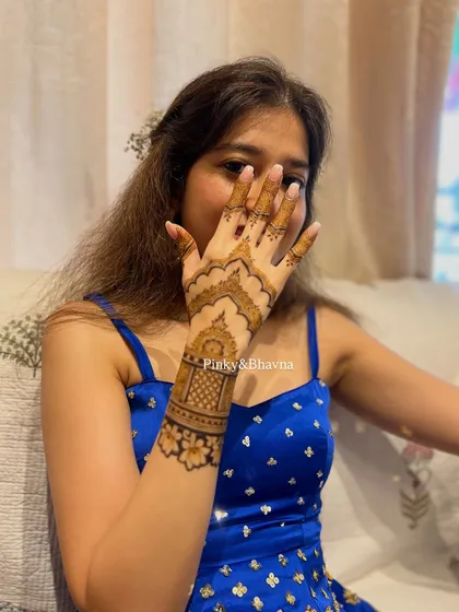 A close up of a simple and elegant back hand design. The architectural motif on the wristband combined with a clean palm makes for a very chic and modern statement.