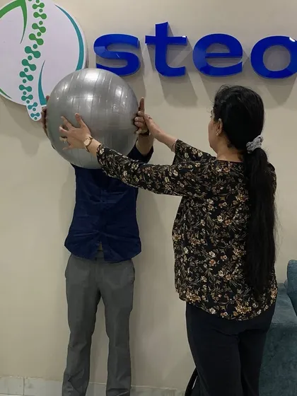 Guiding a patient through a stability exercise using a Swiss ball. A crucial part of my process is ensuring you perform each movement correctly and safely to restore strength and function. Your dedication combined with my guidance is the key to recovery.