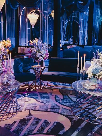 An intimate seating arrangement with stylish spiral tables and lush floral centerpieces, allowing guests to relax and enjoy the performances in comfort.