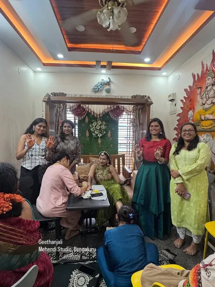 A snapshot of a busy day at my studio, with me applying bridal mehendi while my students and guests look on. It's a great learning environment.