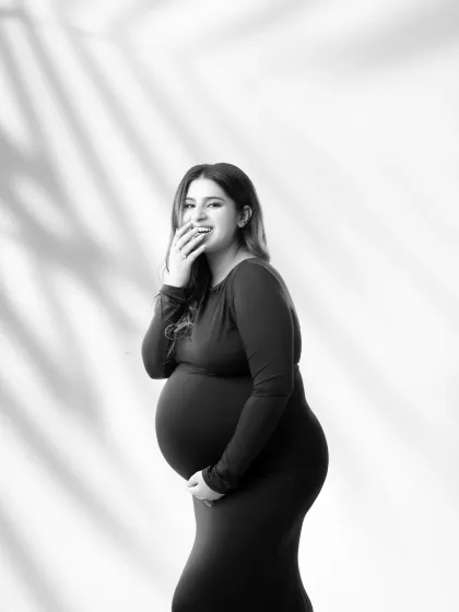 A candid moment of laughter. This black and white shot captures the pure joy and happiness of pregnancy, making for an authentic and heartwarming portrait.