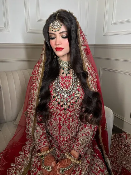 For my Walima brides, I offer looks that blend sophistication and boldness. This heavily layered Polki and gemstone set in red and green, paired with a statement maang tikka, is perfect for a grand reception.