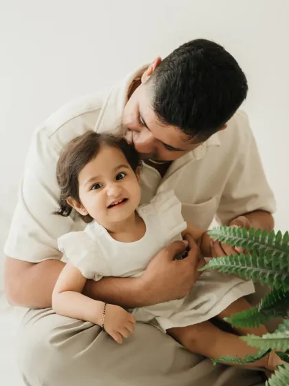 A father tickles his smiling daughter. This playful interaction is a perfect example of a candid father-daughter moment.