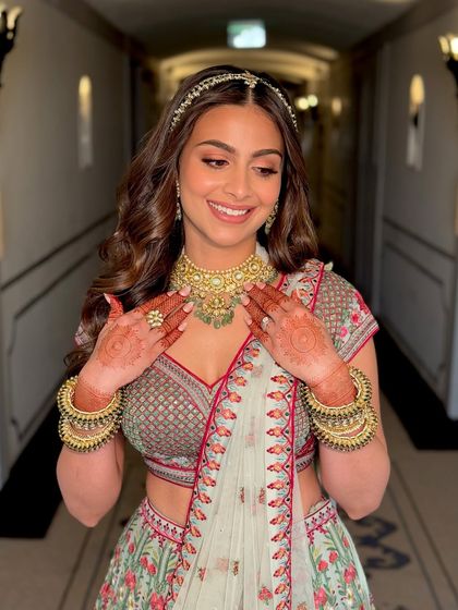 This shot captures the bride's joyful expression and the intricate details of her Mehendi look. The focus is on radiant skin and eyes that sparkle, reflecting her happiness.