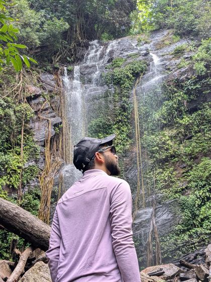 A trekker looks up at the cascading Hidlumane Falls, a truly humbling sight.