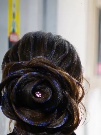 A close-up of the glitter-detailed rose bun, highlighting the texture and sparkle that makes this style so unique.