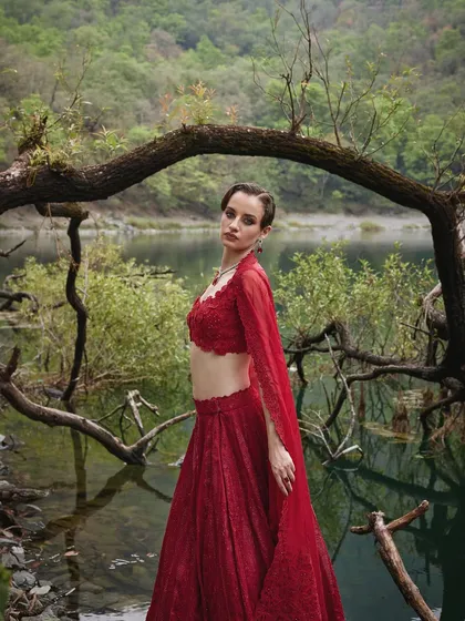 This stunning red lehenga from the Que Sera Sera collection is a harmonious blend of tradition and contemporary flair, perfect for a bride seeking a transcendent experience.