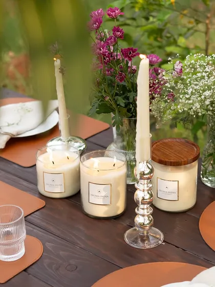 The warm light from our soy wax jar candles and classic tapers illuminates an elegant outdoor table setting. Mixing different candle heights and styles adds depth and visual interest to your decor.