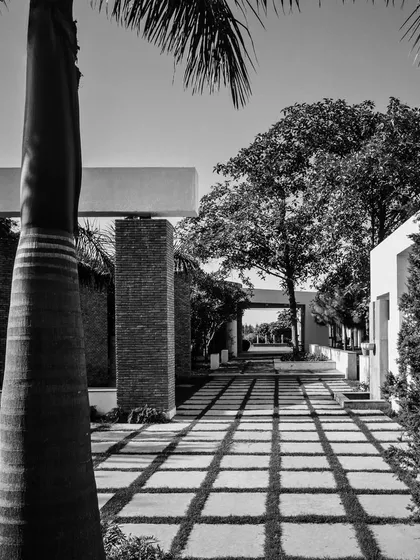 From our archives, the House of Axes in New Delhi. This black and white photo shows a long, shaded walkway, where the play of light and shadow creates a strong geometric pattern.