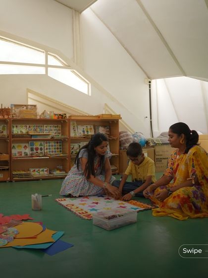 A hands-on learning session in the bright, open space of the kindergarten. The architecture is designed to facilitate collaborative and creative activities.